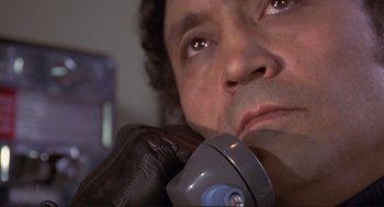 Movie still from “High Anxiety” (1977), directed by Mel Brooks – A man's face while holding a cell phone to his ear; Close Up shot, Low angle