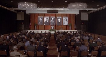 Movie still from “High Anxiety” (1977), directed by Mel Brooks – A crowd of people sitting in front of a podium; Extreme Wide shot, High angle