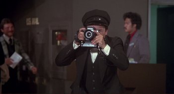 Movie still from “High Anxiety” (1977), directed by Mel Brooks – A man taking a picture of himself with a camera; Medium shot, Low angle