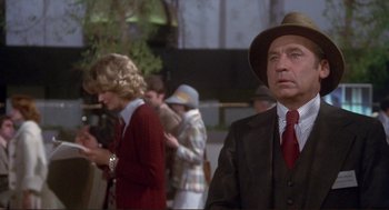 Movie still from “High Anxiety” (1977), directed by Mel Brooks – A man in a suit and a red tie standing in front of a crowd of onlookers; Medium shot, Low angle