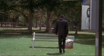 Movie still from “High Anxiety” (1977), directed by Mel Brooks – A man in a black suit is walking away from a bench; Wide shot, High angle