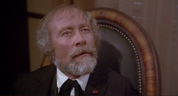 Movie still from “High Anxiety” (1977), directed by Mel Brooks – An older man with a beard sitting in a chair; Close Up shot, High angle