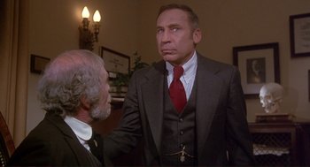 Movie still from “High Anxiety” (1977), directed by Mel Brooks – A man in a suit talking to another man in a suit; Close Up shot, Low angle
