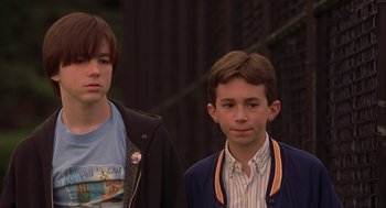 Movie still from “High Fidelity” (2000), directed by Stephen Frears – Two young men standing next to each other; Medium shot, Over the shoulder angle