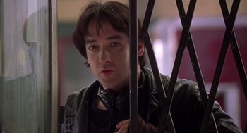 Movie still from “High Fidelity” (2000), directed by Stephen Frears – A man with headphones looking at the camera; Close Up shot, Low angle