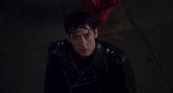 Movie still from “High Fidelity” (2000), directed by Stephen Frears – A man in a leather jacket looking at the camera; Close Up shot, Over the shoulder angle