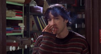 Movie still from “High Fidelity” (2000), directed by Stephen Frears – A man with blue hair is smoking a cigarette; Close Up shot, Over the shoulder angle