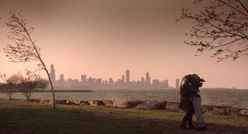 Movie still from “High Fidelity” (2000), directed by Stephen Frears – Two people walking on the grass near a body of water; Extreme Wide shot, Low angle