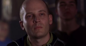 Movie still from “High Fidelity” (2000), directed by Stephen Frears – A man with a bald head looking into the camera; Close Up shot, Low angle