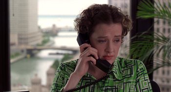 Movie still from “High Fidelity” (2000), directed by Stephen Frears – A woman talking on a phone while wearing a green shirt; Medium shot, High angle