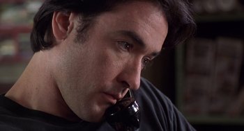 Movie still from “High Fidelity” (2000), directed by Stephen Frears – A person holding a glass of wine; Close Up shot, Low angle