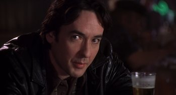 Movie still from “High Fidelity” (2000), directed by Stephen Frears – A person wearing a leather jacket; Close Up shot, Low angle
