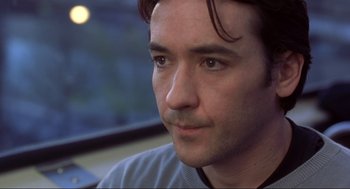 Movie still from “High Fidelity” (2000), directed by Stephen Frears – A man's face as he looks into the distance; Close Up shot, Over the shoulder angle