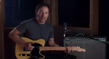 Movie still from “High Fidelity” (2000), directed by Stephen Frears – A man holding a guitar in front of an amplifier; Medium shot, Low angle