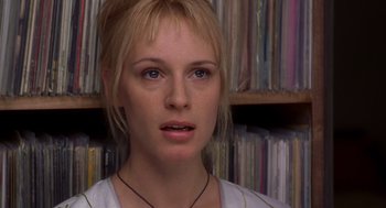 Movie still from “High Fidelity” (2000), directed by Stephen Frears – A person in front of a bookshelf; Close Up shot, Over the shoulder angle