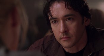 Movie still from “High Fidelity” (2000), directed by Stephen Frears – A man's face in a dark room; Close Up shot, Over the shoulder angle