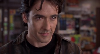 Movie still from “High Fidelity” (2000), directed by Stephen Frears – A person wearing a leather jacket; Close Up shot, Over the shoulder angle