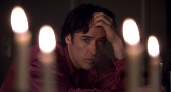 Movie still from “High Fidelity” (2000), directed by Stephen Frears – A man with his hand on his head looking at the camera; Close Up shot, Low angle