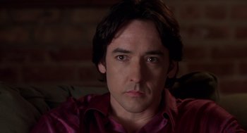 Movie still from “High Fidelity” (2000), directed by Stephen Frears – A person wearing a red shirt; Close Up shot, Low angle