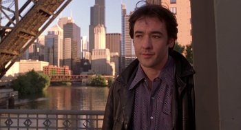 Movie still from “High Fidelity” (2000), directed by Stephen Frears – A person near a body of water with a city skyline in the background; Close Up shot, Over the shoulder angle
