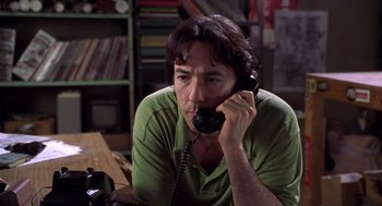 Movie still from “High Fidelity” (2000), directed by Stephen Frears – A man sitting at a table talking on a phone; Close Up shot, Low angle