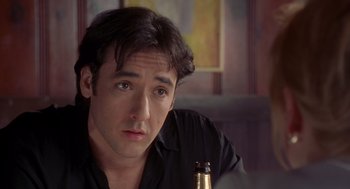 Movie still from “High Fidelity” (2000), directed by Stephen Frears – A person holding a bottle of beer; Close Up shot, Over the shoulder angle
