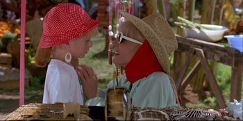 Movie still from “High Heels” (1991), directed by Pedro Almodóvar – A woman and a child wearing hats and earrings; Close Up shot, Over the shoulder angle