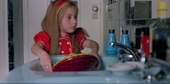 Movie still from “High Heels” (1991), directed by Pedro Almodóvar – A girl sitting at a sink in a room; Close Up shot, Low angle