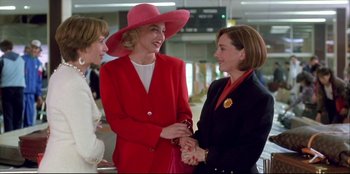 Movie still from “High Heels” (1991), directed by Pedro Almodóvar – A group of women standing next to each other talking; Medium shot, Low angle