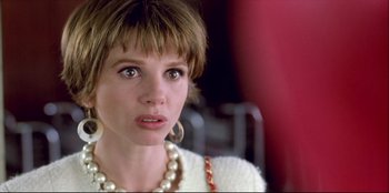 Movie still from “High Heels” (1991), directed by Pedro Almodóvar – A person wearing a necklace; Close Up shot, Over the shoulder angle