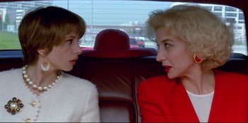 Movie still from “High Heels” (1991), directed by Pedro Almodóvar – Two women sitting in the back seat of a car; Close Up shot, Low angle