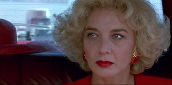 Movie still from “High Heels” (1991), directed by Pedro Almodóvar – A person with blonde hair and red lipstick; Close Up shot, Low angle