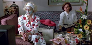 Movie still from “High Heels” (1991), directed by Pedro Almodóvar – Two women sitting at a table with a cake; Medium shot, High angle