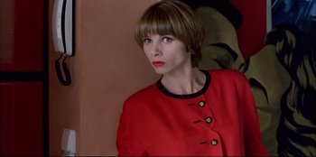Movie still from “High Heels” (1991), directed by Pedro Almodóvar – A woman wearing a red jacket with a black collar; Close Up shot, Low angle