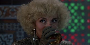 Movie still from “High Heels” (1991), directed by Pedro Almodóvar – A woman drinking a glass of red wine; Close Up shot, Over the shoulder angle