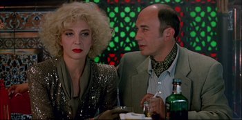 Movie still from “High Heels” (1991), directed by Pedro Almodóvar – A man and a woman sitting next to each other at a table; Close Up shot, Low angle
