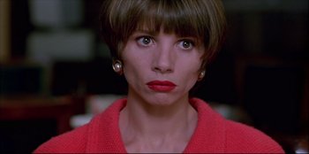 Movie still from “High Heels” (1991), directed by Pedro Almodóvar – A person with short hair wearing a red sweater; Close Up shot, High angle