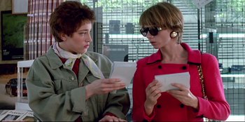 Movie still from “High Heels” (1991), directed by Pedro Almodóvar – Two women are looking at a piece of paper; Medium shot, Low angle