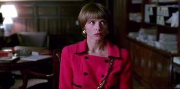 Movie still from “High Heels” (1991), directed by Pedro Almodóvar – A woman in a pink coat looking at the camera; Close Up shot, Low angle