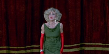 Movie still from “High Heels” (1991), directed by Pedro Almodóvar – A woman in a green dress and red gloves; Medium shot, Low angle