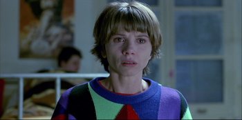 Movie still from “High Heels” (1991), directed by Pedro Almodóvar – A woman with short hair wearing a colorful sweater; Close Up shot, Low angle