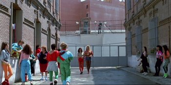 Movie still from “High Heels” (1991), directed by Pedro Almodóvar – A group of people walking down a sidewalk; Wide shot, Low angle