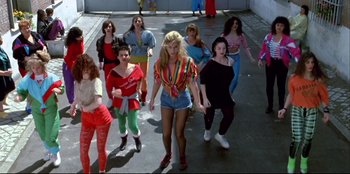 Movie still from “High Heels” (1991), directed by Pedro Almodóvar – A group of women are walking down the street; Wide shot, Low angle