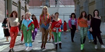 Movie still from “High Heels” (1991), directed by Pedro Almodóvar – A group of young people walking down a sidewalk; Wide shot, Low angle