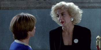 Movie still from “High Heels” (1991), directed by Pedro Almodóvar – An older woman talking to a young boy in front of a wall; Close Up shot, Over the shoulder angle