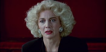 Movie still from “High Heels” (1991), directed by Pedro Almodóvar – An older woman with blonde curly hair wearing a black jacket; Close Up shot, Low angle