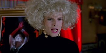 Movie still from “High Heels” (1991), directed by Pedro Almodóvar – A woman with a blonde wig on her head; Close Up shot, Low angle
