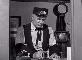 Movie still from “High Noon” (1952), directed by Fred Zinnemann – An older man wearing a train conductor's hat; Medium shot, Low angle