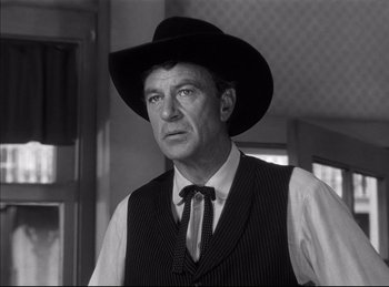 Movie still from “High Noon” (1952), directed by Fred Zinnemann – A man wearing a black hat and a vest; Close Up shot, Low angle