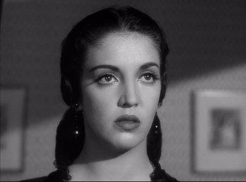 Movie still from “High Noon” (1952), directed by Fred Zinnemann – A black and white photo of a woman with long earrings; Close Up shot, Low angle